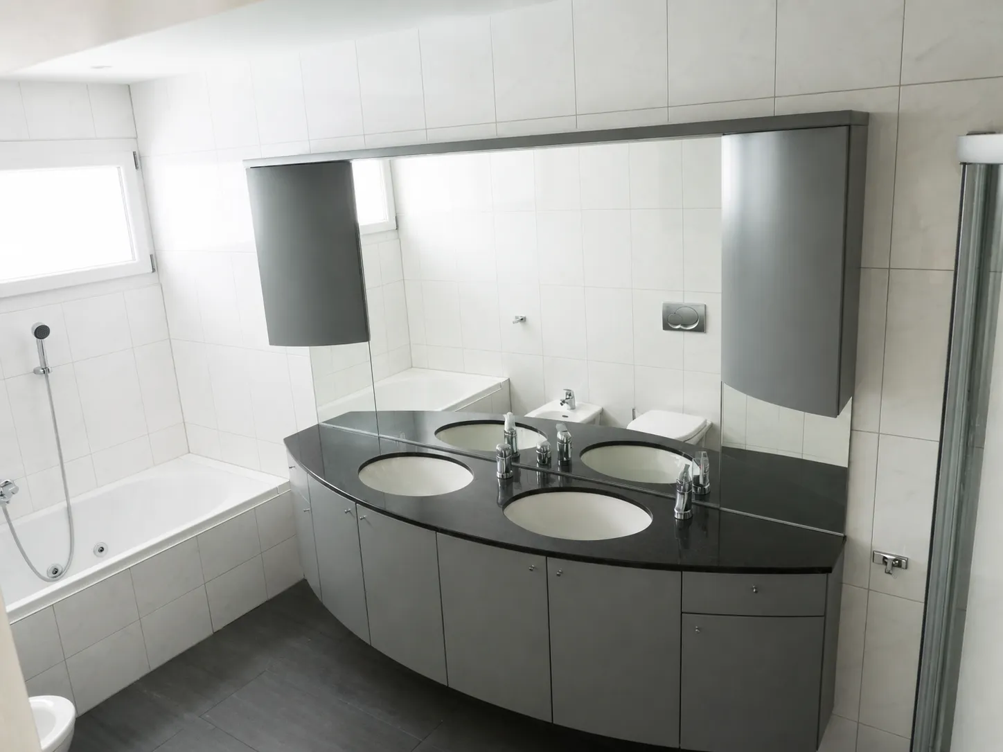 Helles Badezimmer mit Doppelwaschtisch und Badewanne