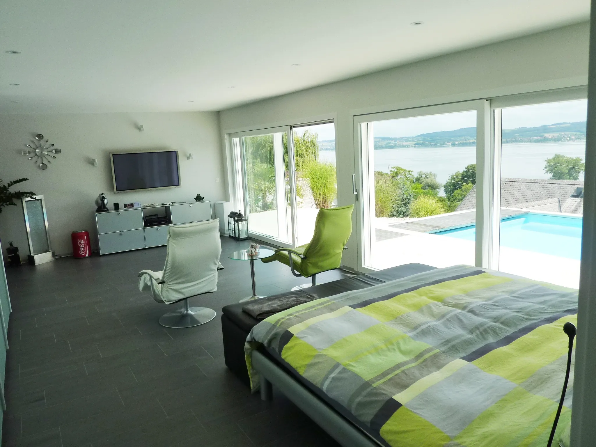 Helles Schlafzimmer mit Blick auf Pool und Murtensee
