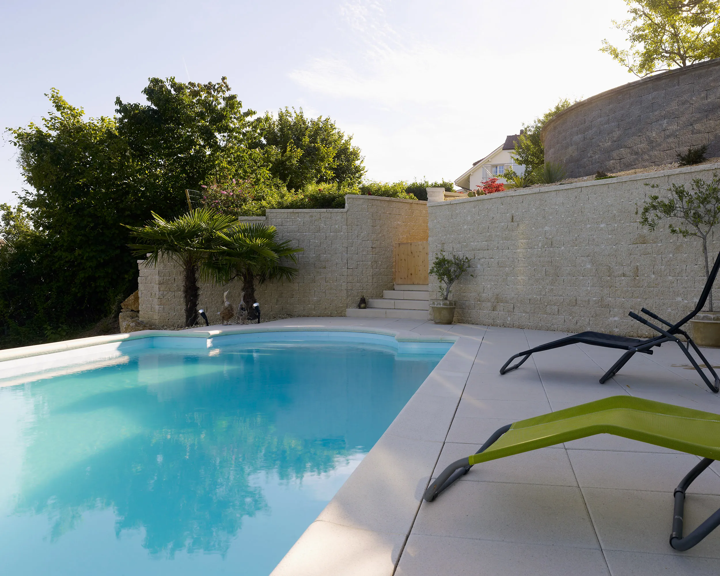 Pool zwischen Natursteinmauern und Garten